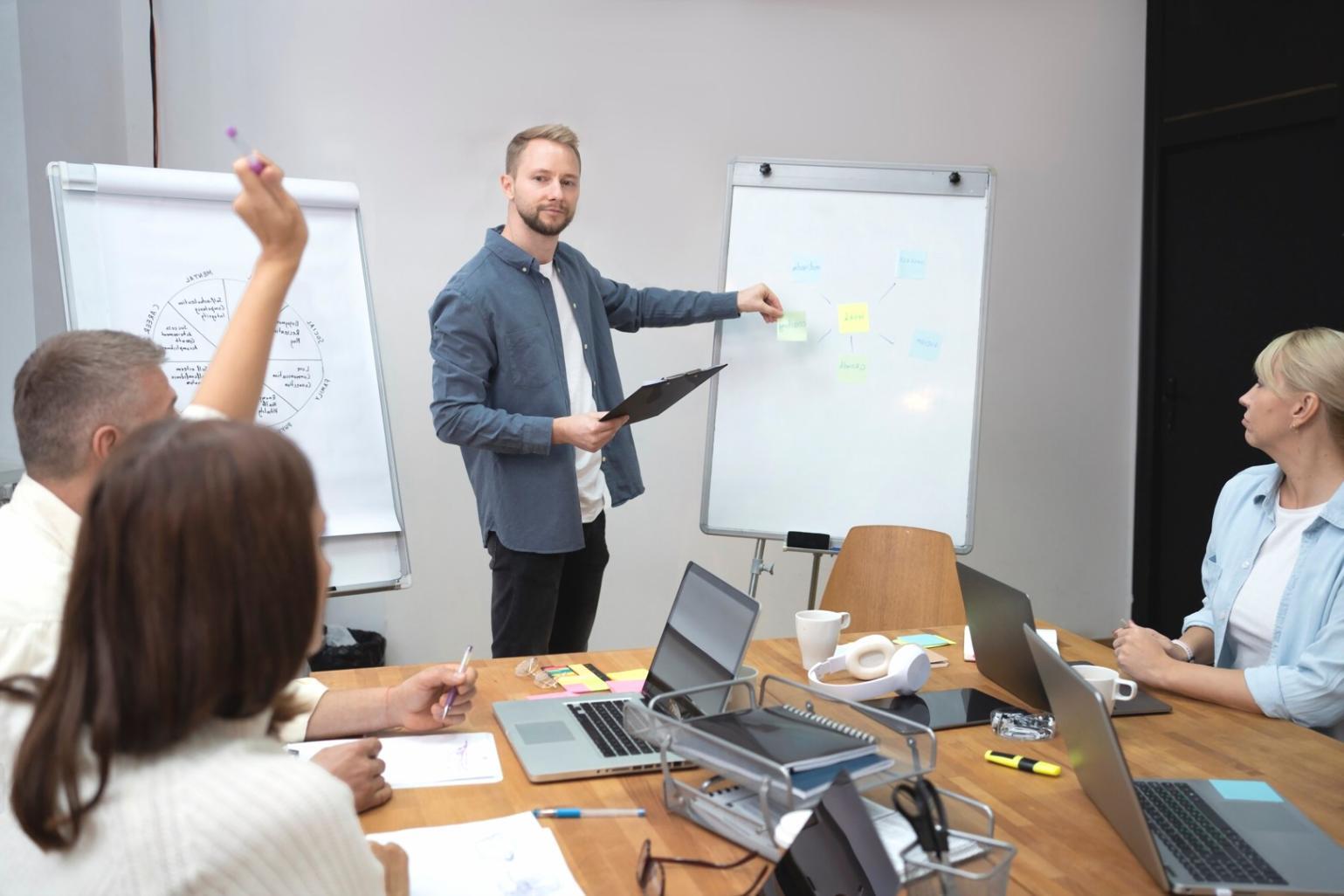 Session de formation avec un instructeur expliquant des concepts financiers à un groupe d'étudiants attentifs
